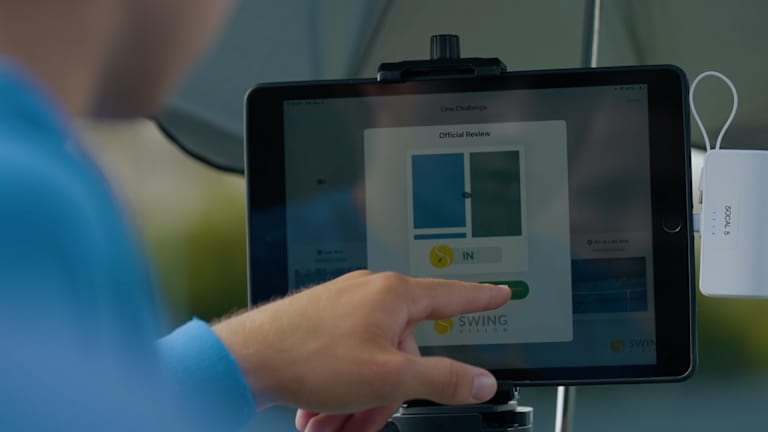 Igrači su pregledali izazove na iPad-u stacioniranom na neto postu.