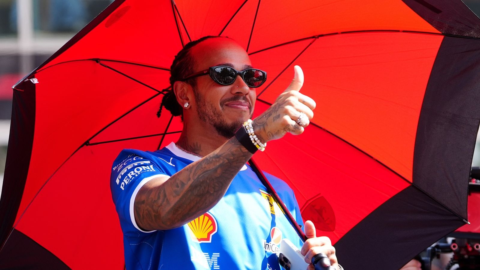 Lewis Hamilton gives a thumbs up to the crowd on the drivers