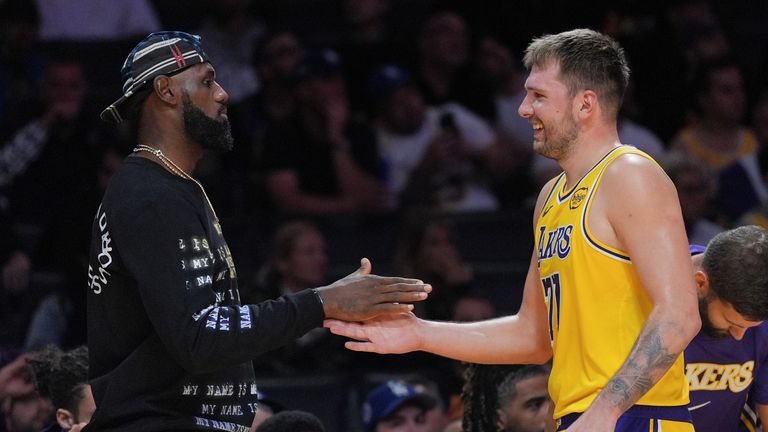 Luku Dončića dočekuje Lebron Džejms tokom predsezonske NBA utakmice protiv Sakramento Kingsa 17. oktobra 2025. (AP Photo/Jae C. Hong)