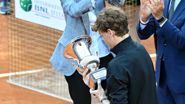 Sinner ispituje trofej, pošto su mu na sceni čestitali italijanski predsednik Serhio Mattarella i šampion iz 1976. godine Adriano Panatta.