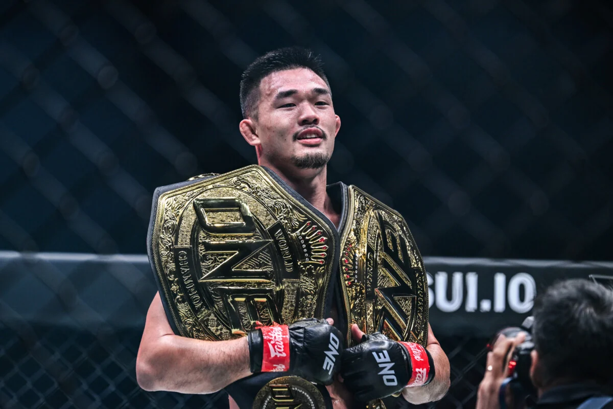 Christian Lee holds his lightweight and welterweight MMA belts.